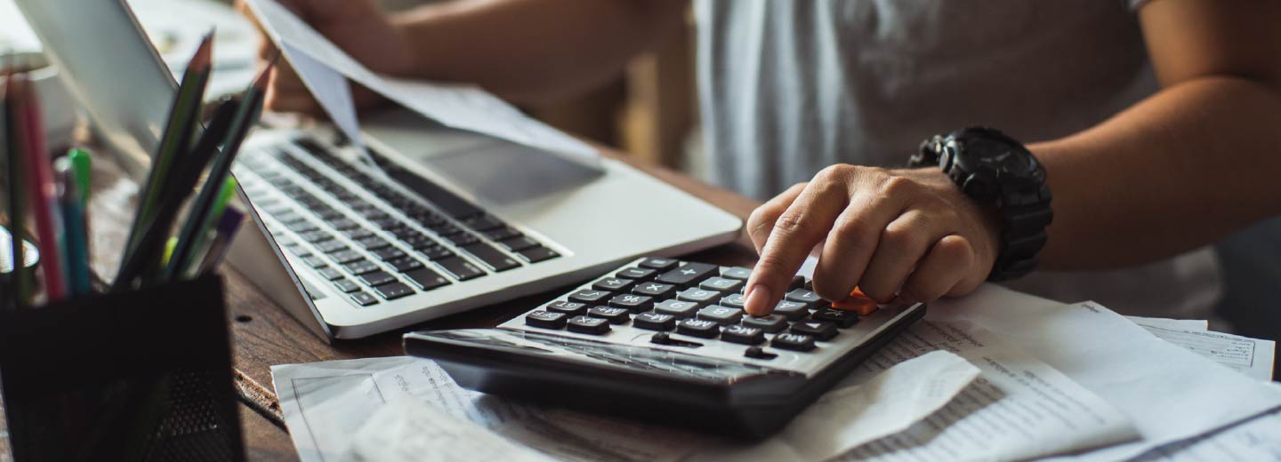 Close up of a person's hands using a calculator.