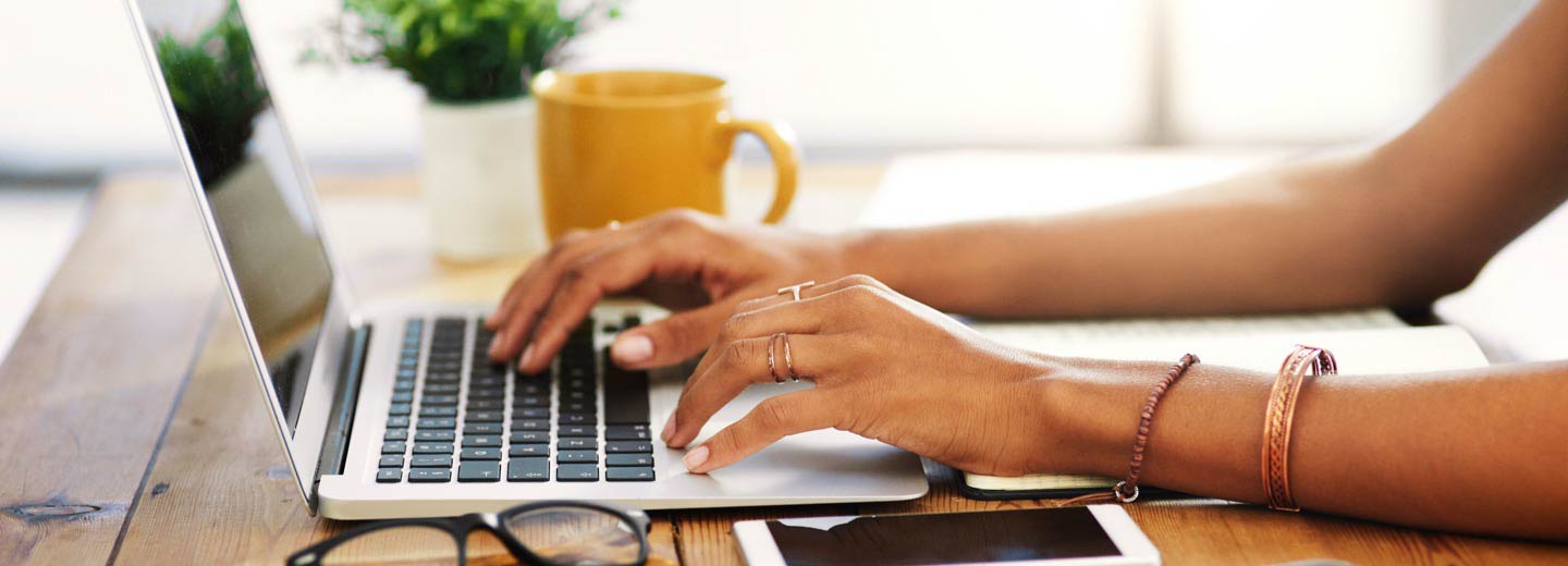 A close-up of someone's hands using a laptop.