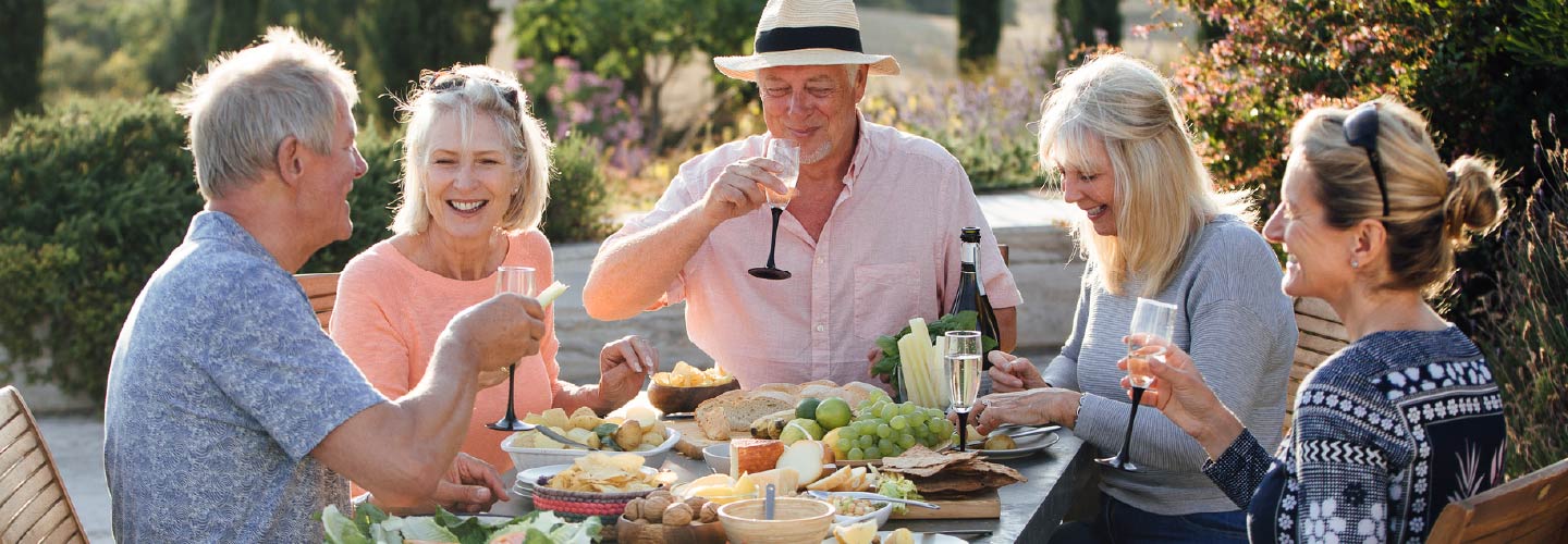 A group of older adults eating outside.