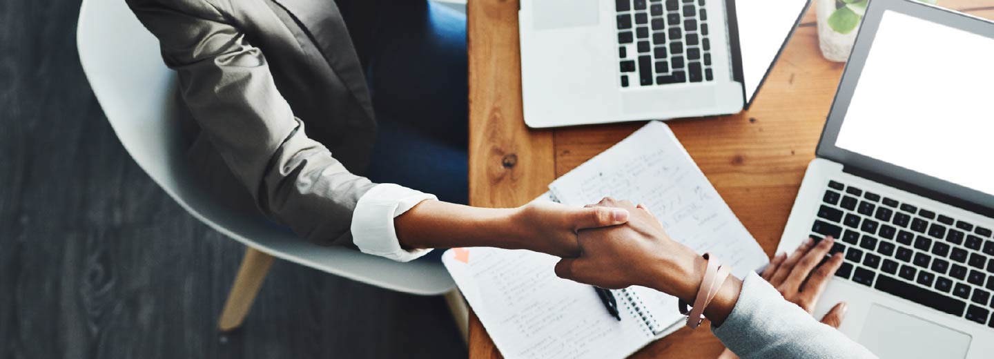 Overhead view of two people shaking hands.