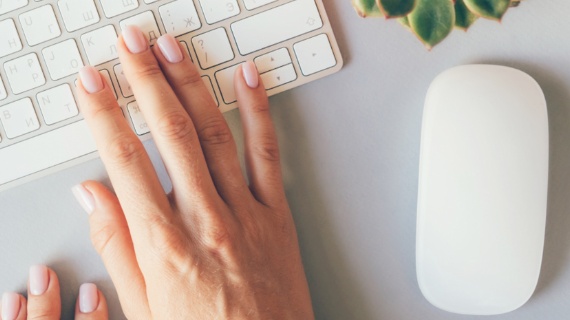 hands on a keyboard next to a mouse