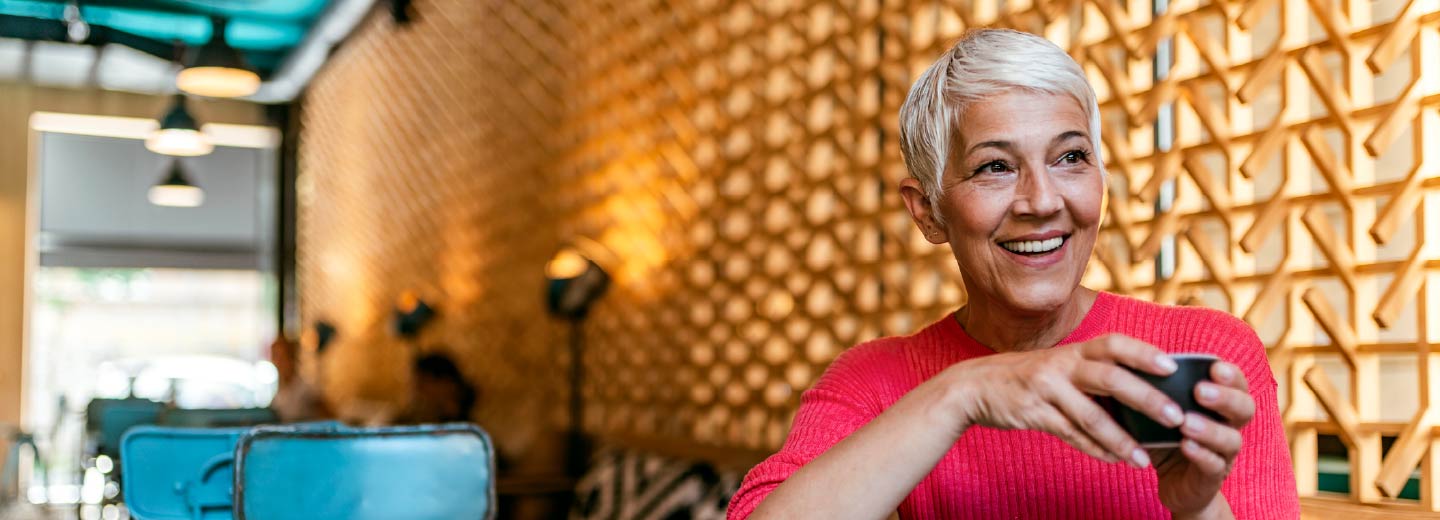 An older woman sitting in a cafe.