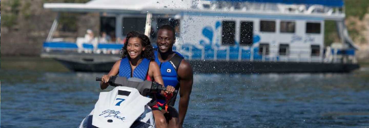 Two people smiling and having fun while riding a jet ski at Lake Cumberland in Somerset, Kentucky.